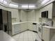 Bright kitchen with white cabinets, white appliances, white countertops and white tiled floors at 6330 Masters Blvd # N4, Orlando, FL 32819
