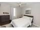 Cozy bedroom with a ceiling fan, large window, dresser, and neutral decor at 635 Cheval Ln, Debary, FL 32713