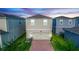 Contemporary home featuring a two-car garage, brick driveway, and green lawn surrounded by neighbor homes at 635 Cheval Ln, Debary, FL 32713