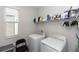 Clean laundry room with white washer and dryer, with a window and storage shelf at 635 Cheval Ln, Debary, FL 32713