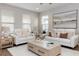 Cozy living room with a light wood coffee table, neutral sofas, throw pillows, and bright natural light at 635 Cheval Ln, Debary, FL 32713