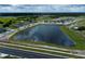 Scenic aerial view of new homes, a tranquil pond, and lush green surroundings, creating a serene community atmosphere at 6717 Yellow Warbler Bnd, St Cloud, FL 34771