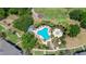 An aerial view showcasing a resort-style community pool with palm trees and many chairs for sunbathing at 7689 Heritage Crossing Way # 202, Reunion, FL 34747