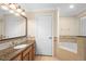 Bathroom featuring vanity, sink, countertop, mirror, tub, and decorative tile at 7689 Heritage Crossing Way # 202, Reunion, FL 34747