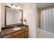 Bathroom features granite countertop, sink, mirror and bathtub with curtain at 7689 Heritage Crossing Way # 202, Reunion, FL 34747