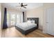 Bedroom boasts wood flooring and a glass door leading to outdoor balcony at 7689 Heritage Crossing Way # 202, Reunion, FL 34747