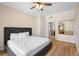 Bedroom with wood floors, large bed, closet doors and entry to ensuite bathroom at 7689 Heritage Crossing Way # 202, Reunion, FL 34747
