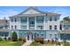 Exterior view of a blue and white condominium building with well manicured landscaping at 7689 Heritage Crossing Way # 202, Reunion, FL 34747