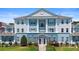 An exterior view features a blue and white condominium building with a well maintained lawn at 7689 Heritage Crossing Way # 202, Reunion, FL 34747
