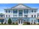 Exterior view showcasing a blue and white condominium building with manicured landscaping at 7689 Heritage Crossing Way # 202, Reunion, FL 34747