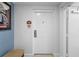 Hallway features a unit door with dark bronze hardware, neutral walls and a patterned bench at 7689 Heritage Crossing Way # 202, Reunion, FL 34747