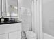 Bright bathroom featuring a vanity with a black countertop, white cabinetry and a shower with white shower curtains at 833 Lockbreeze Dr, Davenport, FL 33897