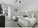 Bright bedroom with two twin beds, neutral decor, and a ceiling fan at 833 Lockbreeze Dr, Davenport, FL 33897
