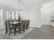 Bright dining room boasts wood-look tile floors, a modern chandelier, and a dining table that seats six people at 833 Lockbreeze Dr, Davenport, FL 33897