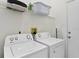 Functional laundry room featuring a side-by-side washer and dryer and storage space for laundry essentials at 833 Lockbreeze Dr, Davenport, FL 33897