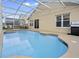 Inviting outdoor pool area featuring a covered patio, space for seating, and a built-in barbecue at 833 Lockbreeze Dr, Davenport, FL 33897