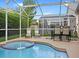 Inviting screened-in pool area with a spa and comfortable outdoor seating for relaxation at 833 Lockbreeze Dr, Davenport, FL 33897