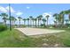 Scenic community volleyball court with lush landscaping and a picturesque lake backdrop at 833 Lockbreeze Dr, Davenport, FL 33897