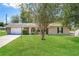 Charming single-story home featuring a well-maintained lawn, a tree, and an attached two-car garage at 845 N Ludlum Dr, Deltona, FL 32725