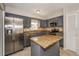 Well-equipped kitchen boasts stainless steel appliances, blue cabinets, granite countertops, and a center island at 845 N Ludlum Dr, Deltona, FL 32725