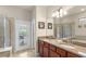 A bathroom with double sinks, granite countertops, a walk-in shower, and access to the backyard at 8804 Rhodes Street, Kissimmee, FL 34747