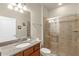 Bathroom with a granite vanity, wood cabinets, toilet, and a glass-enclosed shower at 8804 Rhodes Street, Kissimmee, FL 34747