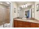 A bathroom featuring double sinks, granite countertops, a glass-enclosed shower, and neutral decor at 8804 Rhodes Street, Kissimmee, FL 34747
