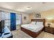 A bedroom with a queen-sized bed, bedside table with a lamp, and a large window at 8804 Rhodes Street, Kissimmee, FL 34747