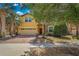 Two-story home with a two-car garage, brick driveway, stone accents, and mature shade trees at 8804 Rhodes Street, Kissimmee, FL 34747