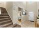 Foyer with tile flooring, staircase, artwork, and view into the bedroom at 8804 Rhodes Street, Kissimmee, FL 34747