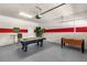 Finished garage with a pool table, foosball table, seating, and a painted accent stripe at 8804 Rhodes Street, Kissimmee, FL 34747