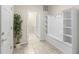 Mudroom with tile flooring, built-in bench, shelves, and a view into the laundry room at 8804 Rhodes Street, Kissimmee, FL 34747
