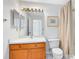 Bathroom showcases a vanity with sink, mirror, and a shower with light brown curtain at 912 Augusta National Blvd, Winter Springs, FL 32708