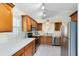 Well-lit kitchen featuring wood cabinetry, modern stainless steel appliances, and white countertops at 912 Augusta National Blvd, Winter Springs, FL 32708