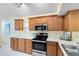 Well-lit kitchen featuring wood cabinetry, modern stainless steel appliances, and white countertops at 912 Augusta National Blvd, Winter Springs, FL 32708