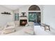 Living room features a fireplace, seating, and access to a patio with lush greenery beyond at 912 Augusta National Blvd, Winter Springs, FL 32708