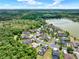 Overhead shot showcasing a suburban neighborhood featuring lush landscaping, a winding road, and a tranquil lake nearby at 955 Holly Springs Ter, Oviedo, FL 32765