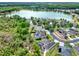 Aerial view showcasing a serene lake surrounded by homes with pools and lush landscaping, creating a tranquil neighborhood setting at 955 Holly Springs Ter, Oviedo, FL 32765