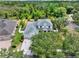 An aerial view showcasing a lovely home with lush landscaping, mature trees, and a well-manicured lawn at 955 Holly Springs Ter, Oviedo, FL 32765