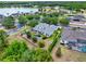 Stunning aerial view of home with lush landscaping, inviting pool and water feature, and serene lake in the background at 955 Holly Springs Ter, Oviedo, FL 32765