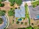 Stunning aerial view of home with a unique backyard pool, lush landscaping, and circular driveway at 955 Holly Springs Ter, Oviedo, FL 32765
