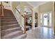 Inviting foyer with staircase, tiled floors, and arched openings to adjacent rooms at 955 Holly Springs Ter, Oviedo, FL 32765