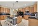 Open kitchen features granite countertops, stainless appliances, center island with seating, and mosaic tile at 955 Holly Springs Ter, Oviedo, FL 32765