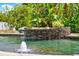 Idyllic pool area with stone accents, tropical foliage, and a tranquil water fountain, perfect for relaxation and privacy at 955 Holly Springs Ter, Oviedo, FL 32765