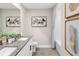 Bright bathroom featuring double sinks, gray tile flooring, and an artistic painting above the toilet at 9980 Red Canoe Aly, Orlando, FL 32832