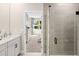 Bathroom view to a bedroom with a glass shower door and a white vanity with black fixtures at 9980 Red Canoe Aly, Orlando, FL 32832