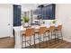 Modern kitchen with navy cabinets, white countertops, a sink and four woven stools facing the counter at 9980 Red Canoe Aly, Orlando, FL 32832