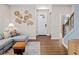 Well lit open concept living area featuring hardwood floors, a white door, and view into the kitchen at 9980 Red Canoe Aly, Orlando, FL 32832