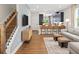 Stylish living area with hardwood floors, an entertainment center, and barstool seating at the kitchen counter at 9980 Red Canoe Aly, Orlando, FL 32832
