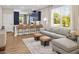 Open concept living space featuring a large window, modern sofa, and kitchen island with seating at 9980 Red Canoe Aly, Orlando, FL 32832